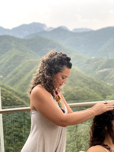 Mariana Guerrero dando una sesión de energía al aire libre, con vista a las montañas